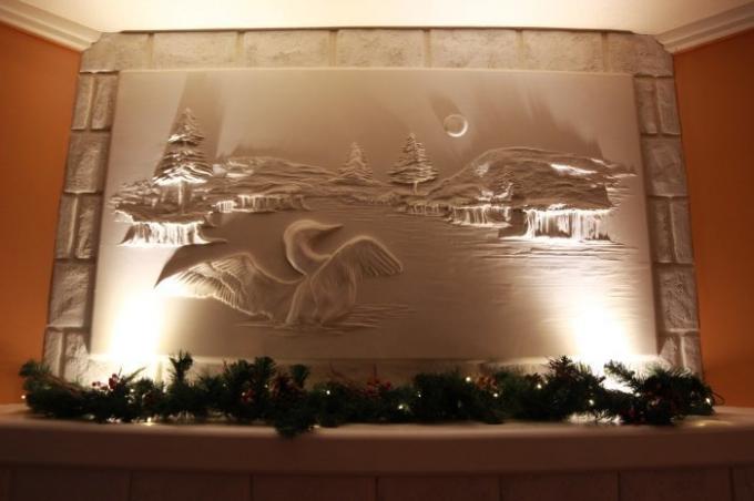 Wild pond with loons - a bas-relief over the mantelpiece. | Photo: berniemitchell.ca.