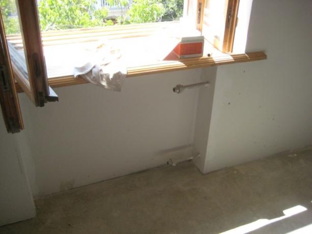 refrigerator in the kitchen under the window