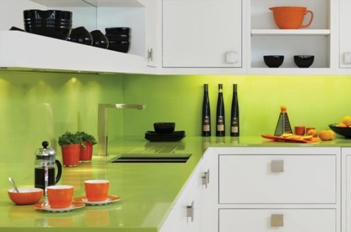The countertop and apron of a bright lime shade look great in combination with white kitchen fronts and orange dishes.