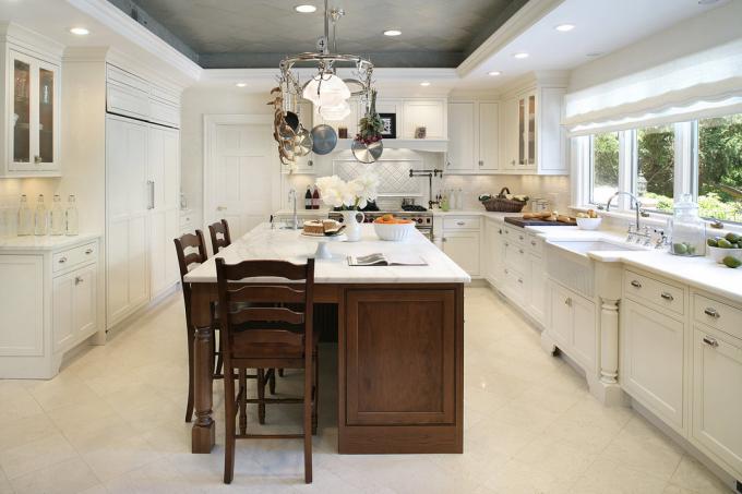 The tiles are in gray to set off a white kitchen, while white drywall matches the overall style of the room.