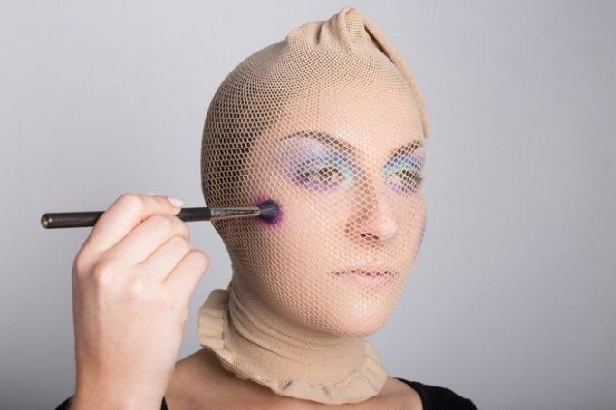 Carey began to apply eye shadow brush makeup directly on top of a stocking-net.