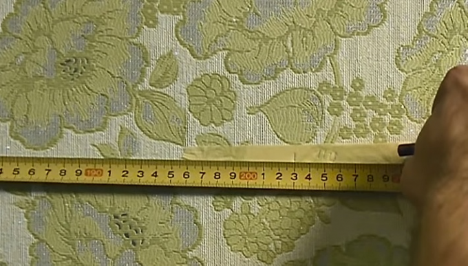 Masking tape will help to make a mark without damaging wallpaper 