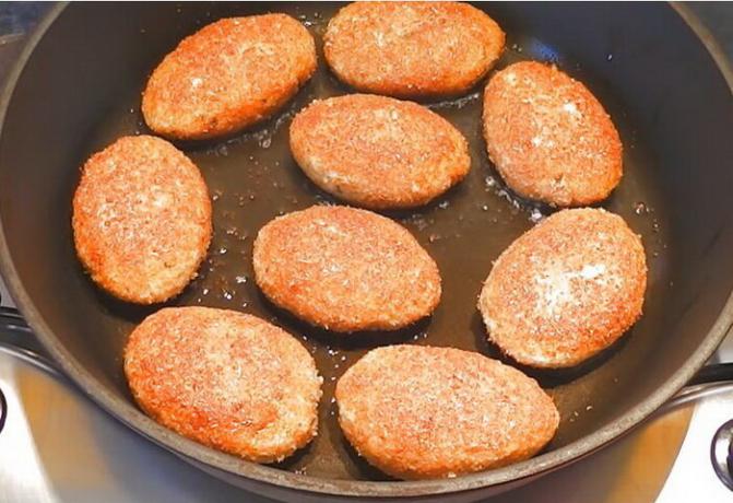 Fried fish cakes in a pan with vegetable oil.
