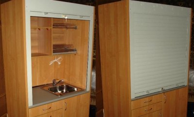 Mini kitchen in a closet with blinds instead of doors